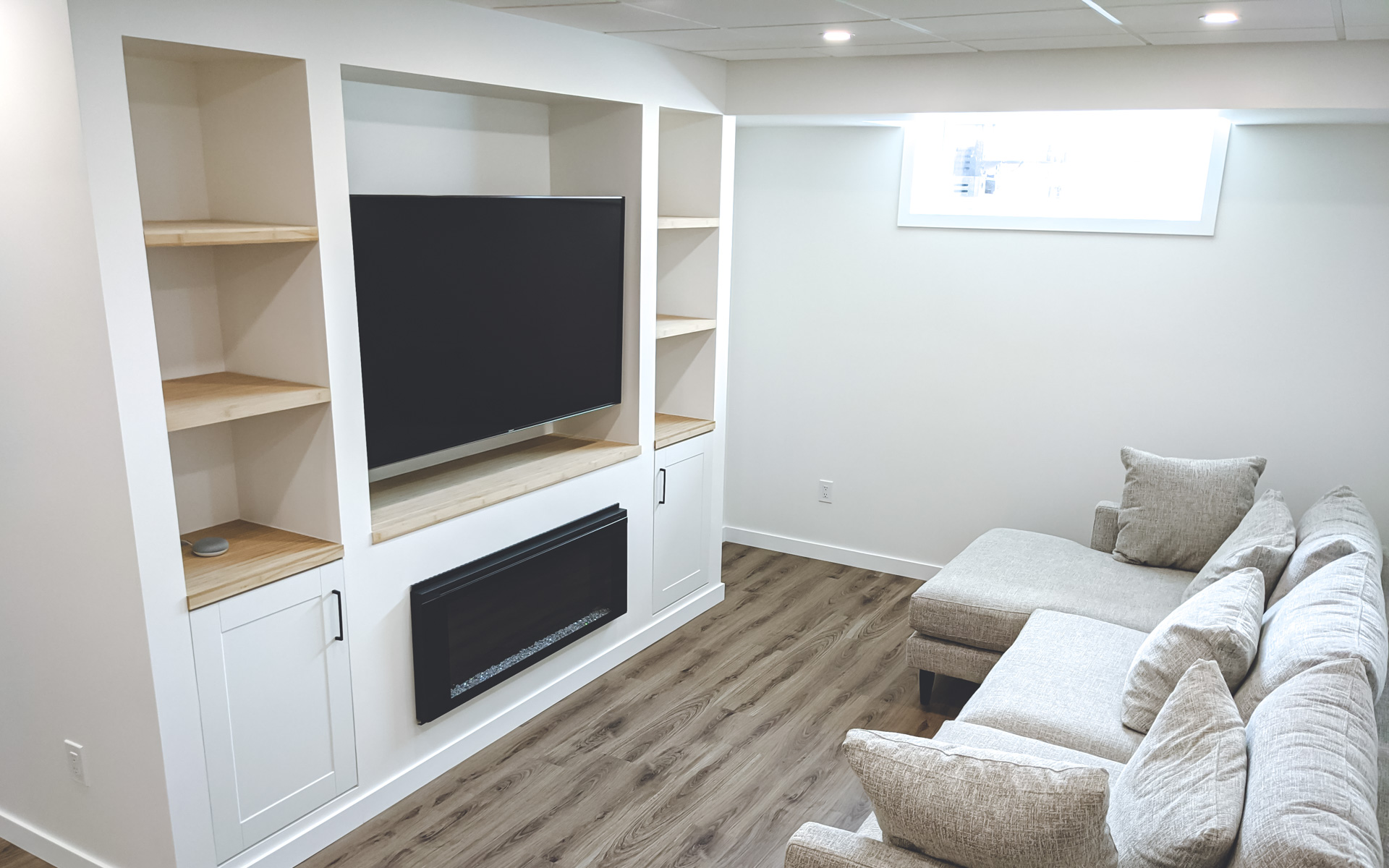 A custom built-in TV unit and recently installed laminate flooring by BZ Carpentry Services in Winnipeg.